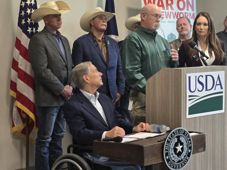 Alan Cain, who directs the wildlife division of Texas Parks and Wildlife, flanked by Texas Governor Greg Abbott, left, and U.S. Agriculture Secretary Brooke Rollins, right, speaks at a news conference in Kerrville on June 9, 2026