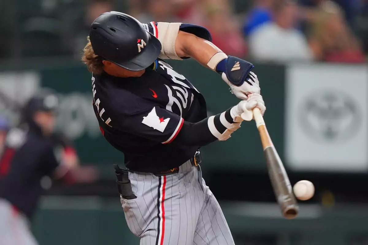 Minnesota Twins' Luke Keaschall hits a single scoring teammate Josh Bell during the fourth inning of a baseball game against the Texas Rangers, Tuesday, June 16, 2026, in Arlington, Texas. (AP Photo/LM Otero)