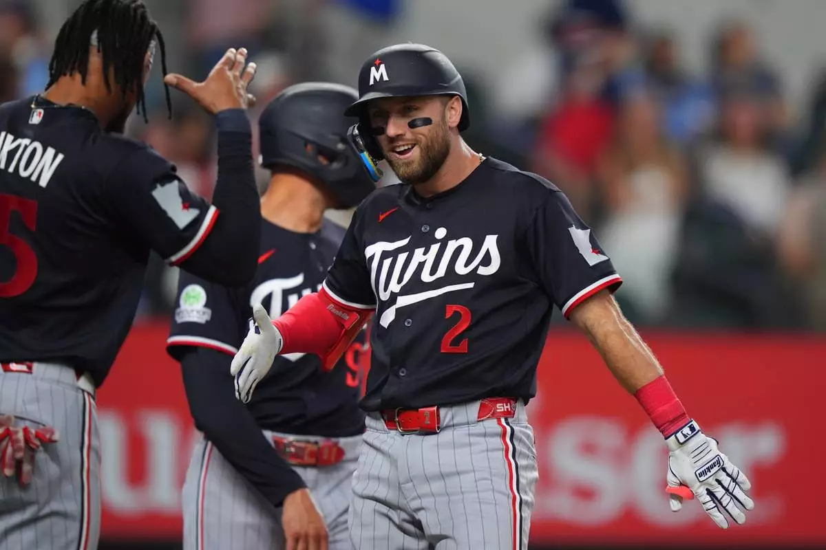 Minnesota Twins' Kody Clemens (2) celebrates his home run that scored teammate's Byron Buxton, left, and Trevor Larnach during the third inning of a baseball game against the Texas Rangers, Tuesday, June 16, 2026, in Arlington, Texas. (AP Photo/LM Otero)