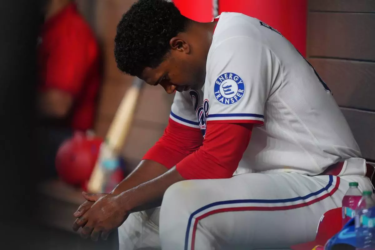 Texas Rangers starting pitcher Kumar Rocker sits on the bench after being pulled during the fourth inning of a baseball game against the Minnesota Twins, Tuesday, June 16, 2026, in Arlington, Texas. (AP Photo/LM Otero)