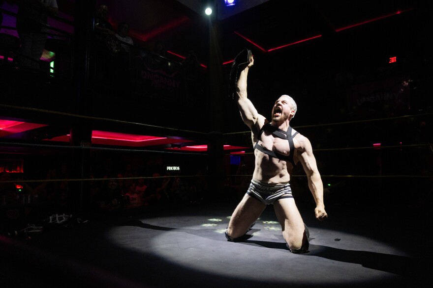Dillon McQueen cheers ahead of his match at Uncanny Attraction’s inclusive wrestling event at Highland Lounge in downtown Austin, Texas, on April 25, 2026. Lorianne Willett/KUT News