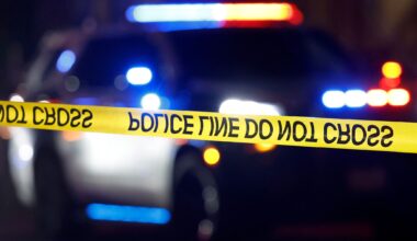 Dallas Police Crime Scene Unit officers investigate the murder of 17-year-old Jaden McMillan who was shot by an unknown suspect at the St. James Manor apartment complex on Easter Ave. in Dallas, July 10, 2025. The teen victim was transported to a local hospital and was pronounced dead. Crime scene tape blocked off a breezeway, littered with at least five evidence markers — one placed next to a black sandal at the bottom of a short concrete staircase.