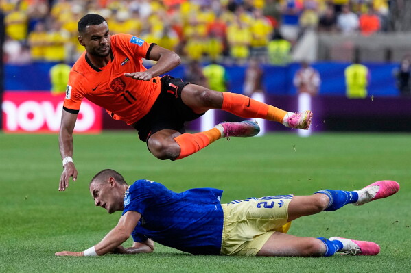 Netherlands' Cody Gakpo falls over Sweden's Gustaf Lagerbielke during the World Cup Group F soccer match between the Netherlands and Sweden in Houston, Saturday, June 20, 2026. (AP Photo/Ashley Landis)