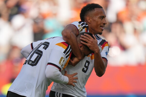 Germany's Deniz Undav, left, celebrates with teammate Germany's Jamie Leweling after scoring their first goal during the World Cup Group E soccer match between Germany and Ivory Coast in Toronto, Saturday, June 20, 2026. (AP Photo/Stephanie Scarbrough)