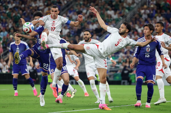 Japan's Takehiro Tomiyasu (22), Tunisia's Ellyes Skhiri (17) and Tunisia's Montassar Talbi (3) battle for the ball during the World Cup Group F soccer match between Tunisia and Japan in Guadalupe, near Monterrey, Mexico, Saturday, June 20, 2026. (AP Photo/Sofia Yaker)