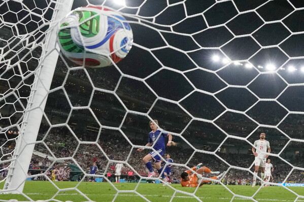 Japan's Junya Ito (14) scores their third goal past Tunisia goalkeeper Aymen Dahmen (16) during the World Cup Group F soccer match between Tunisia and Japan in Guadalupe, near Monterrey, Mexico, Saturday, June 20, 2026. (AP Photo/Dolores Ochoa)