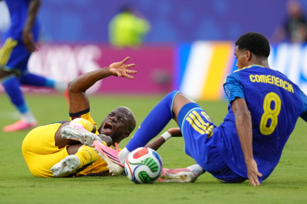 Ecuador's Enner Valencia, left and Curaçao's Livano Comenencia fall during a World Cup Group E soccer match in Kansas City, Mo., Saturday, June 20, 2026. (AP Photo/Ed Zurga)