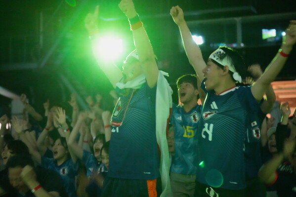 People react to Japan's first goal as they watch their World Cup Group F soccer match against Tunisia in Mexico, during a public viewing event in Tokyo, Sunday, June 21, 2026. (AP Photo/Hiro Komae)
