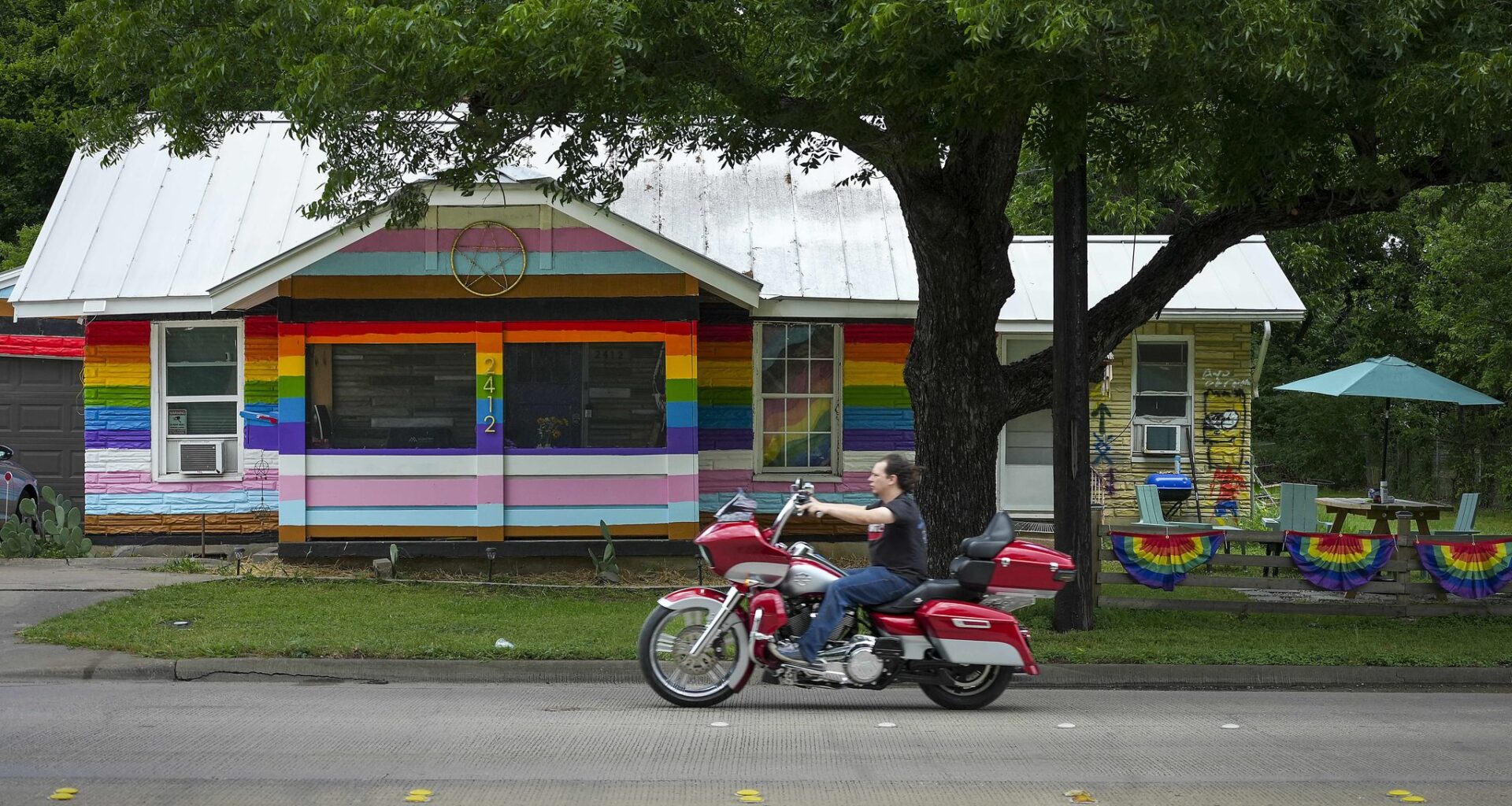 Traffic passes Liam Yesko’s rainbow painted home in Haltom City, Saturday, June 6, 2026.  Yesko painted his Haltom City house to support the LGBTQ community during Pride month after Gov. Greg Abbott required cities to remove all rainbow crosswalks.