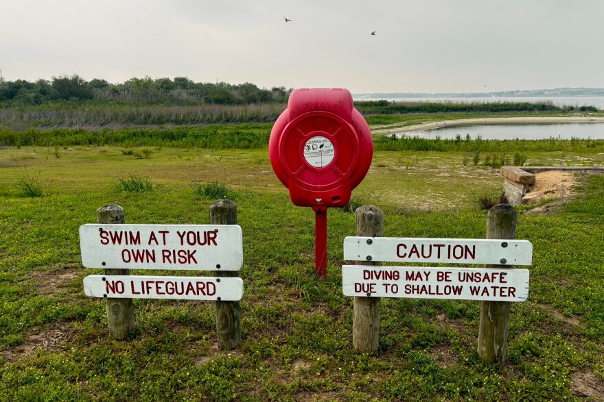 Lake Corpus Christi dropped below 10 percent full in March, the lowest on record since it was first filled in the late 1950s. Signs about swimming sit far from the water's edge on April 28.