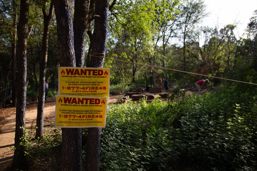 Wanted signs are posted outside on a tree near an area where a sculpture once sat.