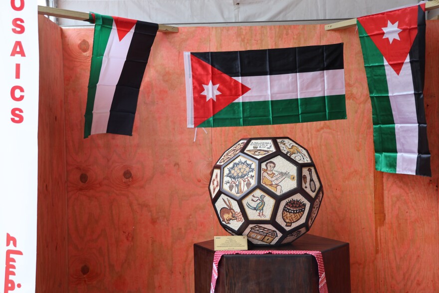 A booth at the Visit Jordan Experience in downtown Arlington on June 25, 2026 displaying Jordanian mosaic art, an ancient handcraft that originated in the city of Madaba.