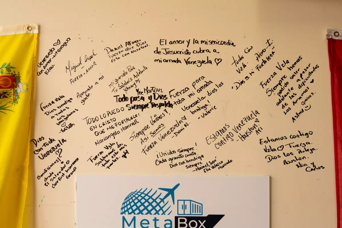Messages of hope and support cover a wall beside a Venezuelan flag at MetaBox Cargo in Katy, Texas, on Thursday.