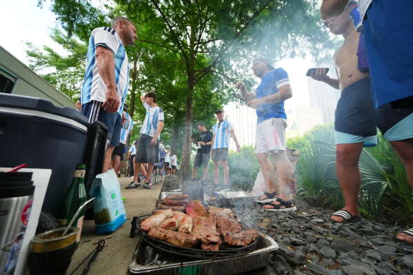 Argentina supporters grill during a rally ahead of their team's World Cup Group J soccer match against Austria, Sunday, June 21, 2026, in Dallas. (AP Photo/Julio Cortez)