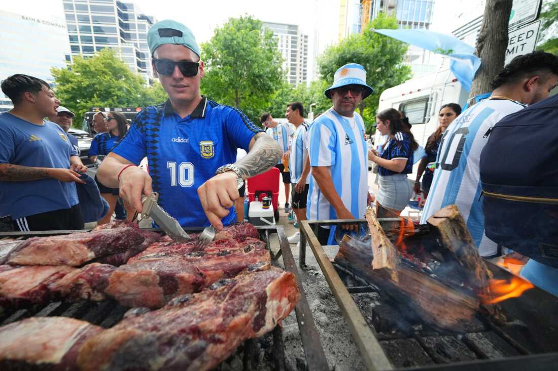 Matias Videla, of Dallas, a supporter of Argentina, checks meat on his grill during a rally ahead of his team's World Cup Group J soccer match against Austria, Sunday, June 21, 2026, in Dallas.