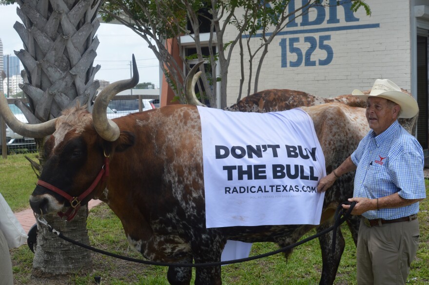 Cattle handlers stand outside the Texas Democratic Convention with a bull wearing a towel that said, “Don’t Buy the Bull,” as part of a campaign stunt sponsored by Gov. Greg Abbott's campaign Radical Texas.