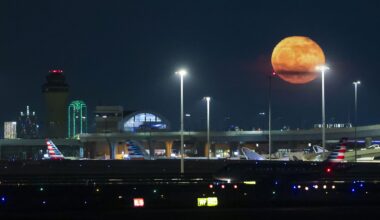 The Blue full moon rises past Dallas Fort Worth International Airport as an American Airlines flight cruises not the run way, on Tuesday, June 2, 2026.