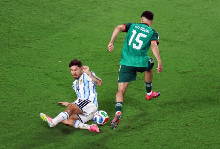 Argentina's Gonzalo Montiel slides under Algeria's Rayan Ait Nour