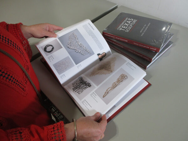 A photograph of a person holding a book open.