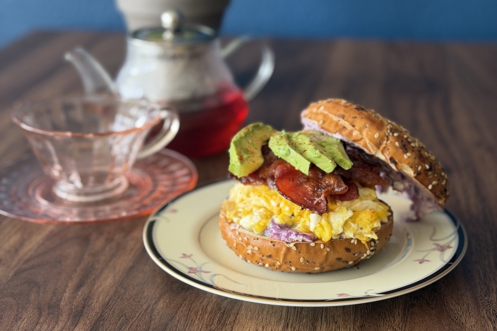 Bagel breakfast sandwich, tea cup, tea pot