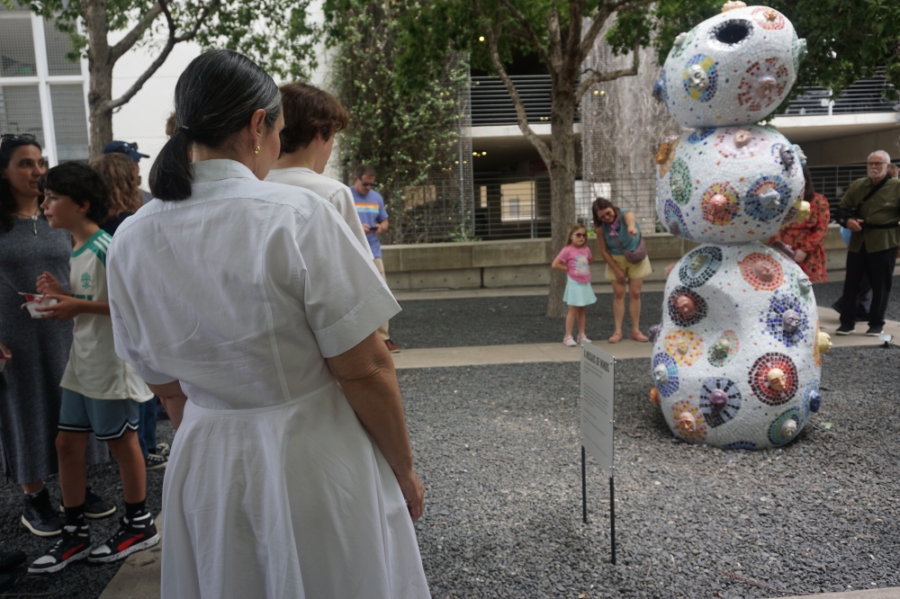 Onlookers view the newly unveiled "Mosaic of Minds" sculpture, permanently located at the AISD Performing Arts Center at 1500 Barbara Jordan Blvd. (Jessica McLaren/Community Impact)