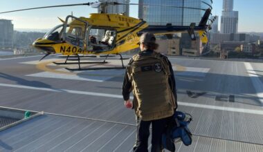 A PHI Air Medical crew member walks toward a helicopter on a rooftop helipad. (Courtesy PHI Air Medical)