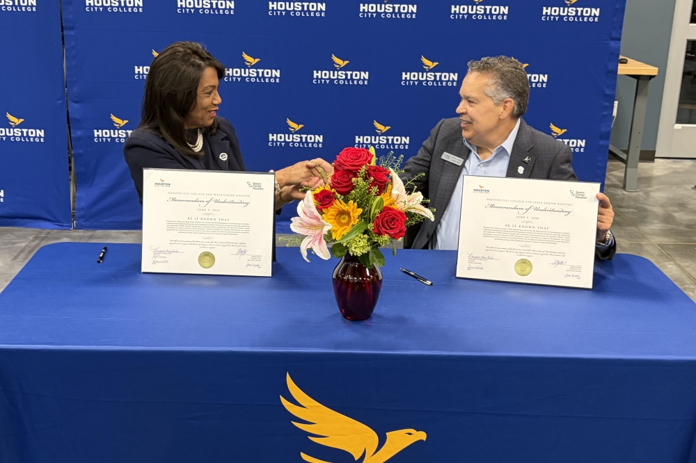 HCC Chancellor Margaret Ford Fisher (left) and William Harris, president and CEO of Space Center Houston, shake hands after signing the memorandum of understanding. (Bradley Dountz/Community Impact)