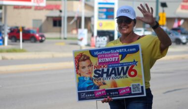 New Braunfels City Council District 6 candidate Nikki Shaw campaigns outside city hall on June 13. (Amira Van Leeuwen/Community Impact)