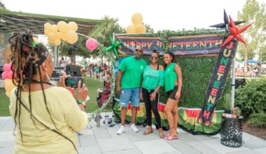 Woman taking a photo of a family during a Juneteenth celebration at Redemption Square
