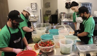 Nolan Stilwell, William Mullican IV and Eric Hernandez cut strawberries and peppers to make Texas Sweet Heat Jam with help from Christine Stilwell. (Daniel Schwalm/Community Impact)