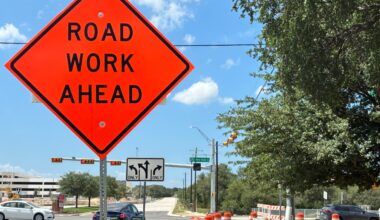 Orange construction barrels and a sign alert drivers to ongoing lane changes at New Hope Drive, where the city is expanding the roadway from four to six lanes and building an innovative intersection at 183A Toll. (Jessica McLaren/Community Impact)
