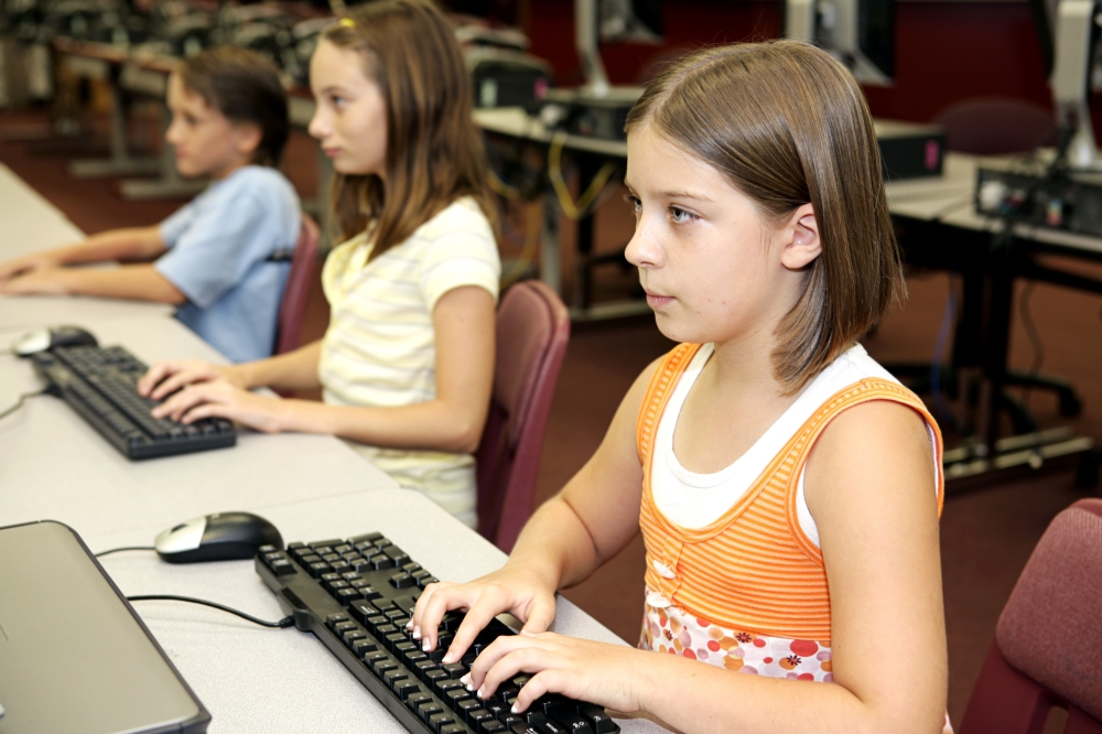 Students in the school library doing research on computers.