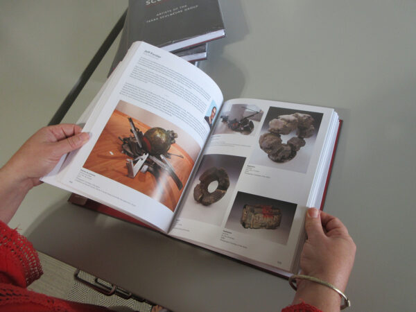 A photograph of a person holding a book open.