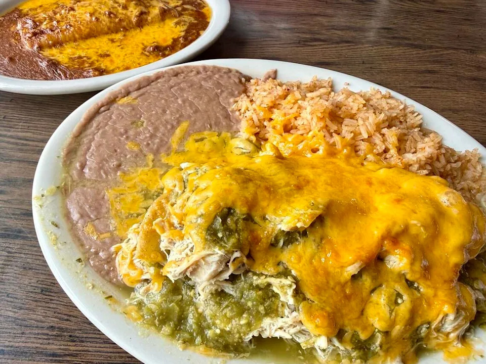 A chicken '‘enchilada pie” with green sauce, foreground, and a cheese enchilada with chili con carne at El Sombrero Restaurant in Saginaw, Texas, seen June 8, 2026.