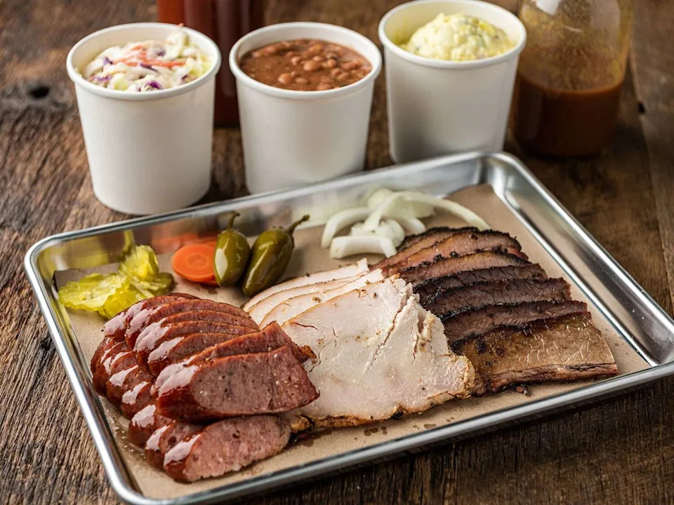 Smokey Mo's BBQ sausage, turkey, and brisket platter with coleslaw and bean sides. (Courtesy of Smokey Mo's)