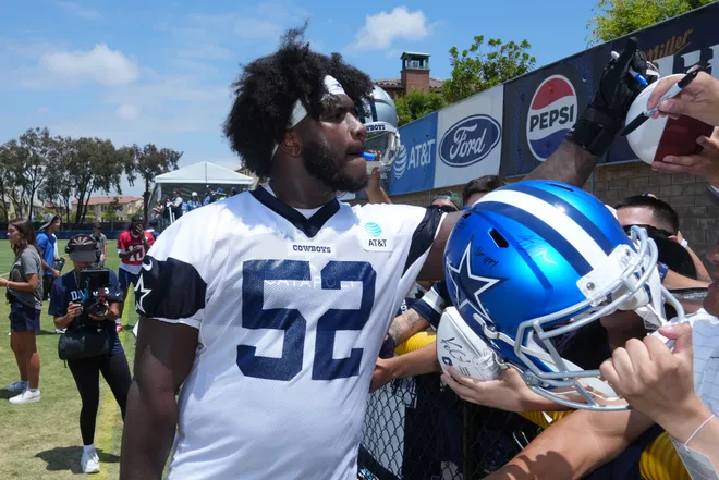 Jul 22, 2025; Oxnard, CA, USA; Dallas Cowboys guard Tyler Booker (52) signs autographs during training camp at the River Ridge Fields. Mandatory Credit: Kirby Lee-Imagn Images