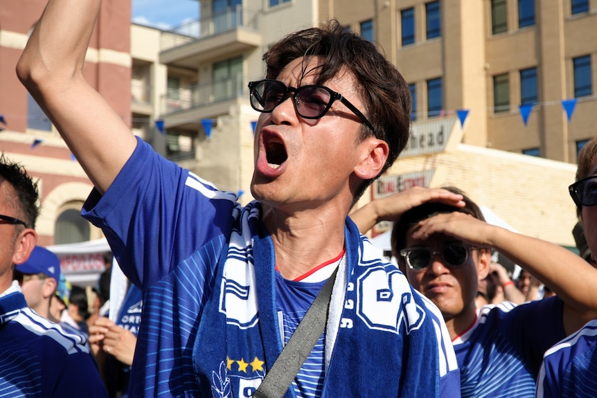 A Japanese fan shouts enthusiastically. 
