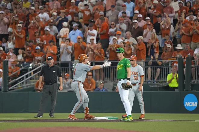 Jun 7, 2026; Austin, TX, USA; Texas Longhorns catcher Carson Tinney (8) reacts ahead of Oregon Ducks first baseman Brayden Jaksa (11) after hitting a single during the second inning of a Super Regional game at UFCU Disch-Falk field in Austin, Texas. Mandatory Credit: Scott Wachter-Imagn Images