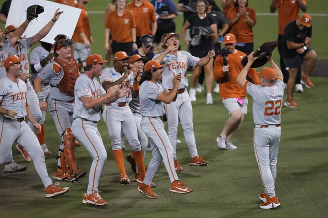 Jun 7, 2026; Austin, TX, USA; Texas Longhorns Head Coach Jim Schlossnagle holds the trophy ahead of players after closing out a Super Regional game over the Oregon Ducks at UFCU Disch-Falk field in Austin, Texas. Mandatory Credit: Scott Wachter-Imagn Images