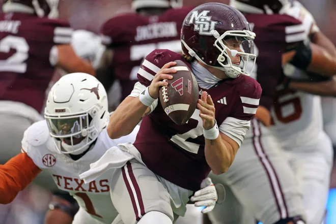 Oct 25, 2025; Starkville, Mississippi, USA; Mississippi State Bulldogs quarterback Blake Shapen (2) scrambles in the backfield as Texas Longhorns defensive linemen Colin Simmons (1) attempts to make the tackle during the second quarter at Davis Wade Stadium at Scott Field. Mandatory Credit: Petre Thomas-Imagn Images