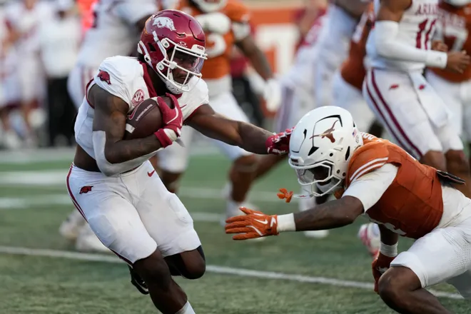 Nov 22, 2025; Austin, Texas, USA; Arkansas Razorbacks quarterback KJ Jackson (7) runs from the pocket while defended by Texas Longhorns defensive back Jelani McDonald (4) during the second half at Darrell K Royal-Texas Memorial Stadium. Mandatory Credit: Scott Wachter-Imagn Images