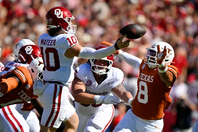 Oct 11, 2025; Dallas, Texas, USA; Oklahoma Sooners quarterback John Mateer (10) throws the ball over Texas Longhorns linebacker Trey Moore (8) during the first half at the Cotton Bowl. Mandatory Credit: Jerome Miron-Imagn Images
