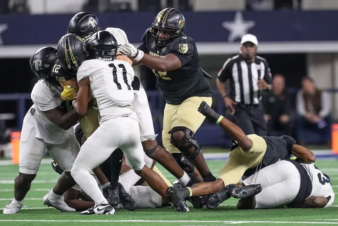South Oak Cliff's Brian Swanson (72) attempts to free quarterback Carter Kopecky (12) during the Class 5A, Division II State Championship game on Friday, Dec. 20, 2024, at AT & T Stadium in Arlington, Texas.