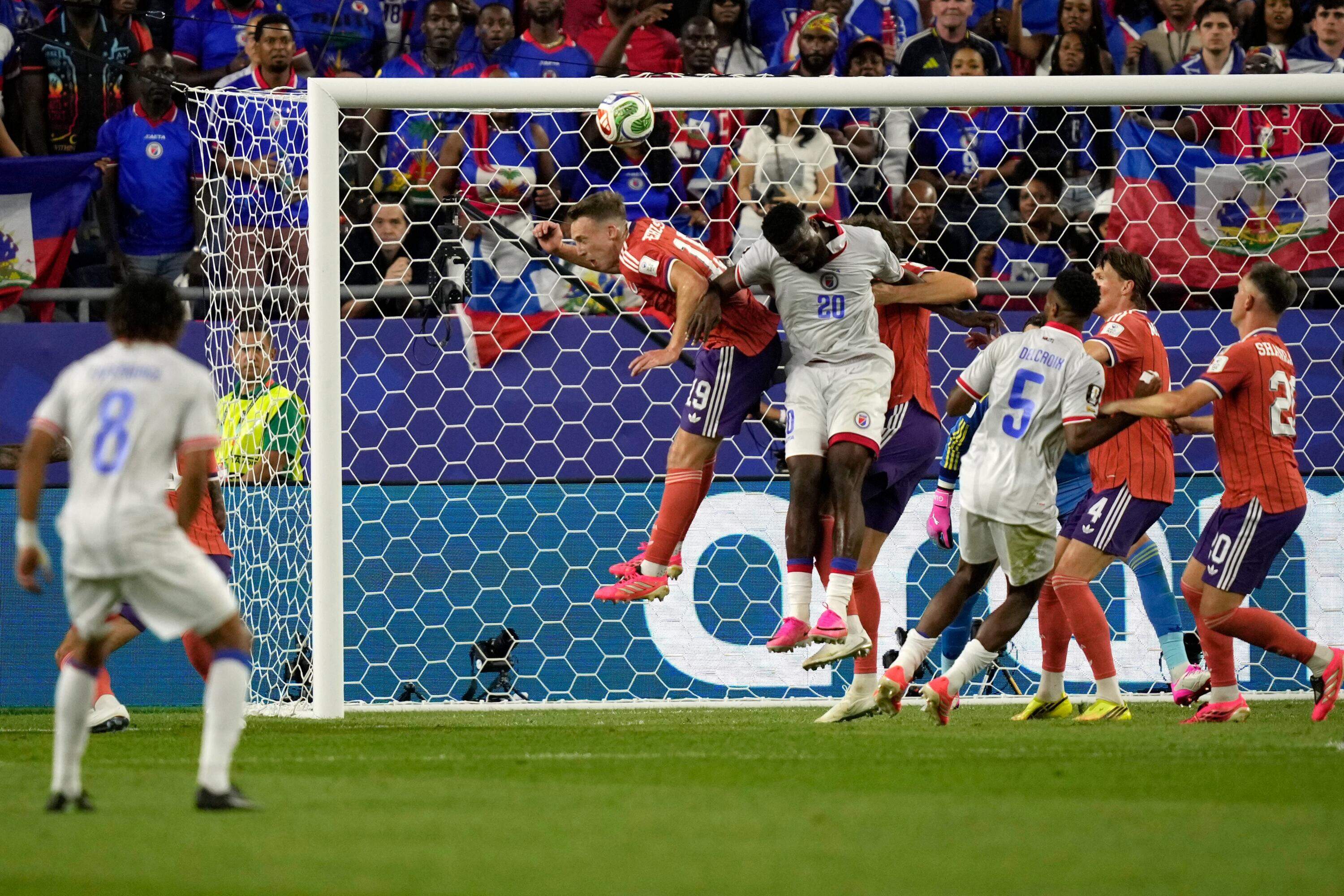 Scotland's Lewis Ferguson (19) and Haiti's Frantzdy Pierrot (20) go up for a header during the World Cup Group C soccer match between Haiti and Scotland in Foxborough. (Charlie Krupa/AP)