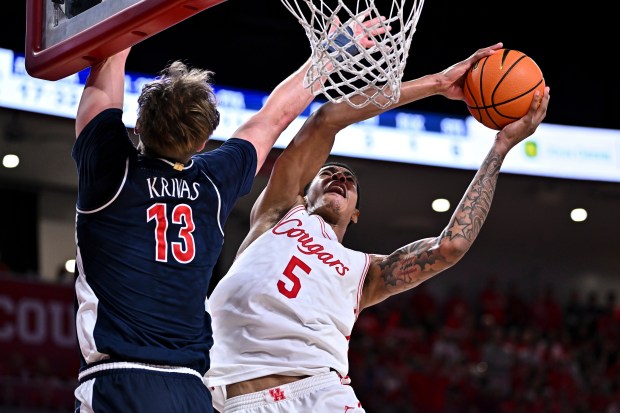 FILE - Houston forward Chris Cenac Jr. (5) shoots the ball as Arizona center Motiejus Krivas (13) defends in the second half of an NCAA college basketball game, Feb. 21, 2026, in Houston. (AP Photo/Maria Lysaker, File)