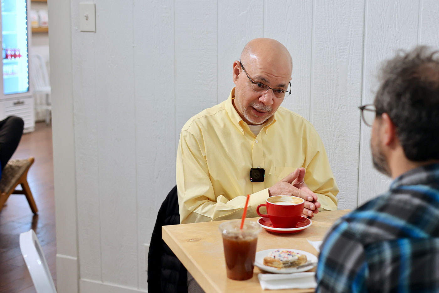 Dr. Abidi speaks with a reporter during an interview at a local coffee shop (left). 