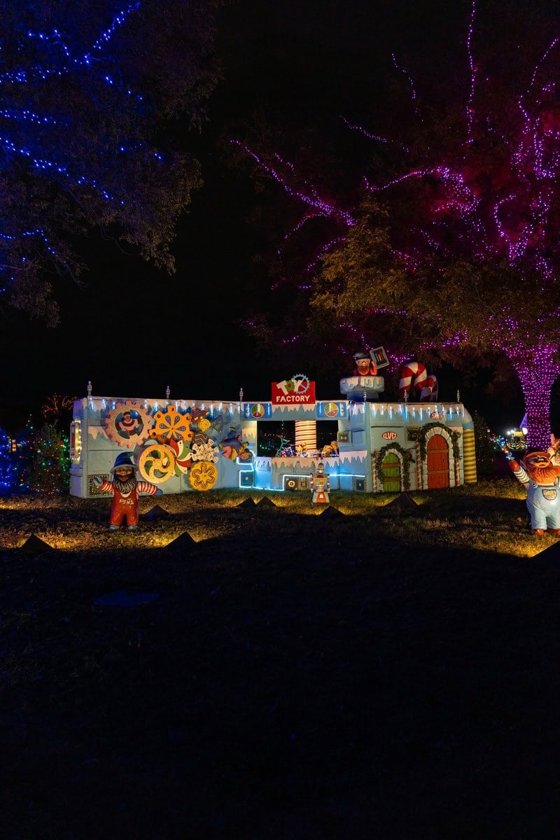 A colorful illuminated toy factory display at night