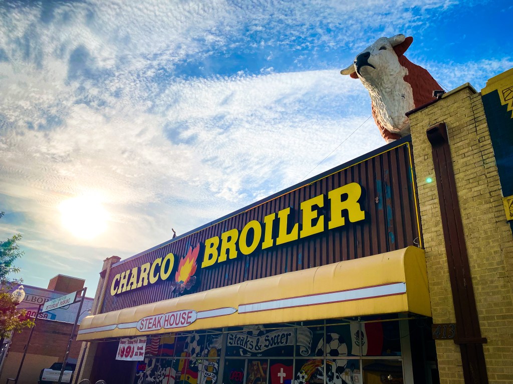 The exterior of charco broiler with a big cow on the roof.