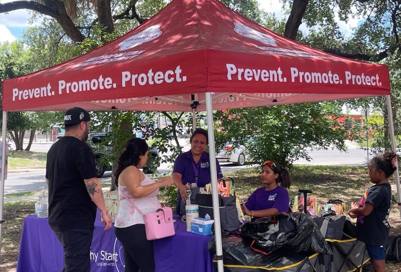 Young parents meet with San Antonio Metro Health staff at an event. 