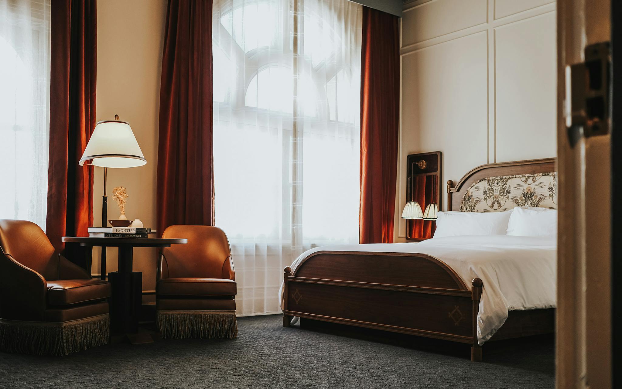 Deep navy and slate monogrammed carpeting, red velvet curtains, and wood and leather furniture offer a cozy retreat.